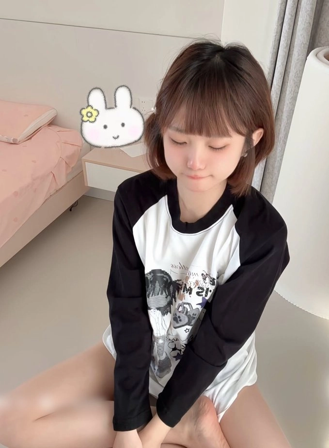 女孩穿着一件黑白衬衫,上面有一只兔子。