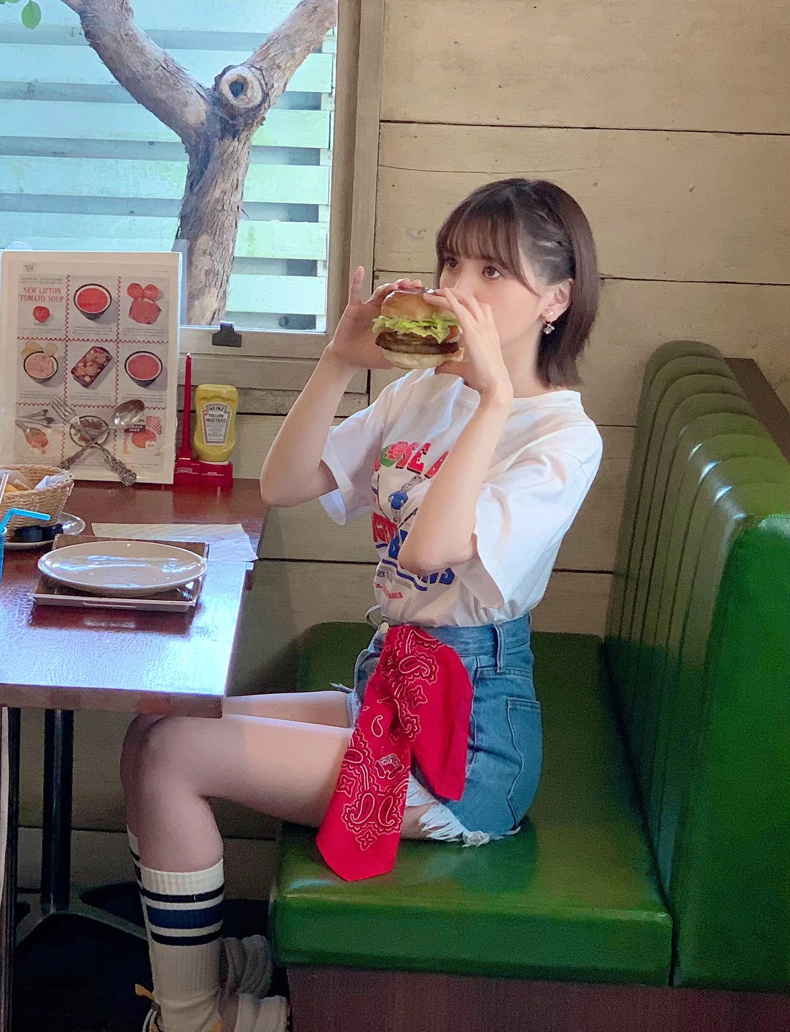 穿白衬衫的女人吃了一顿三明治。