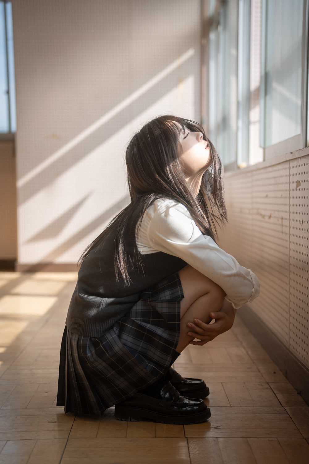 长头发和黑色裙子的女孩正在窗外看。