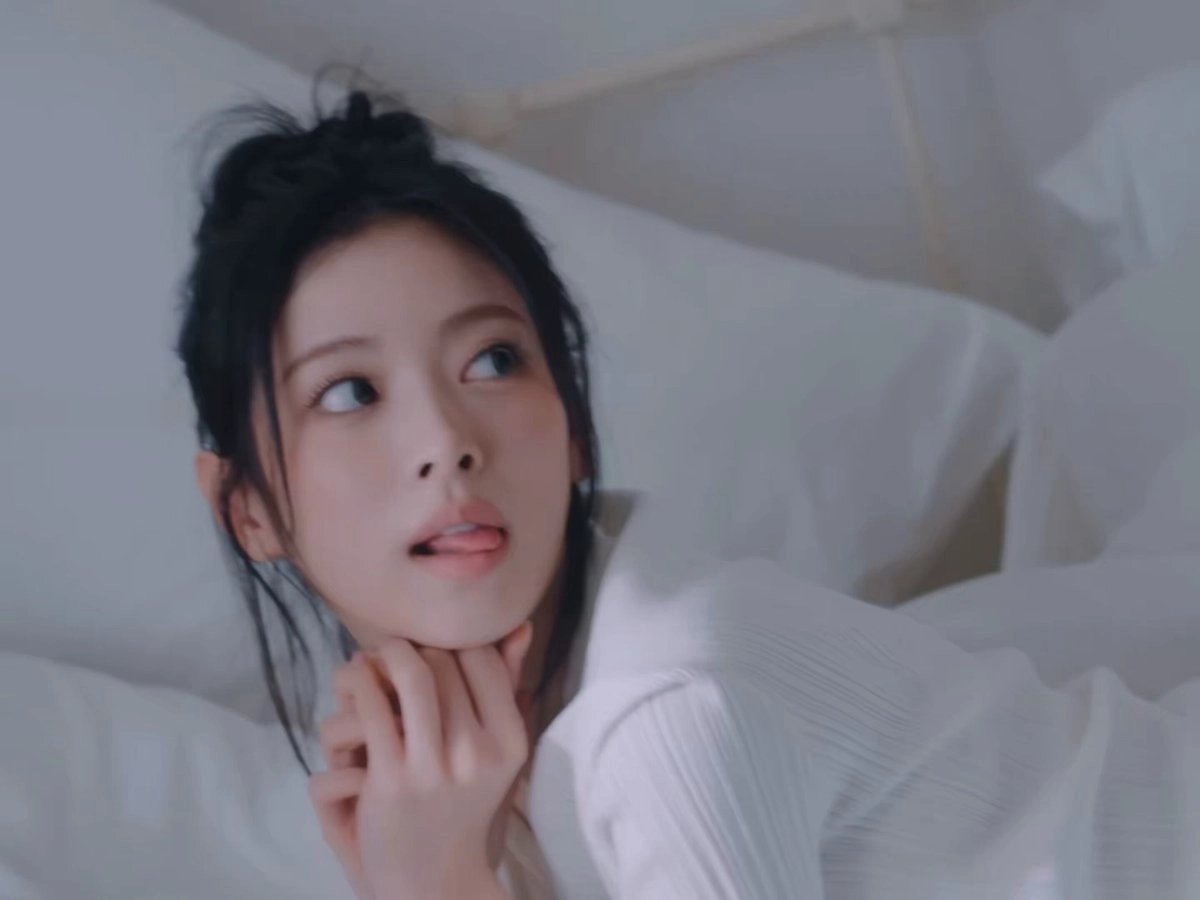 黑头发和白衬衫的女人躺在床上。