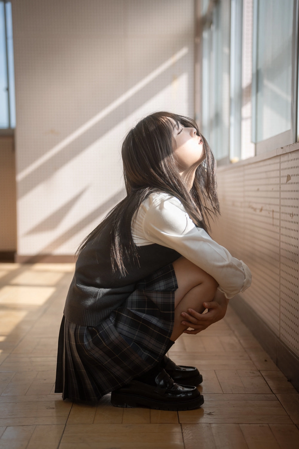 长头发和黑色裙子的女孩正在窗外看。