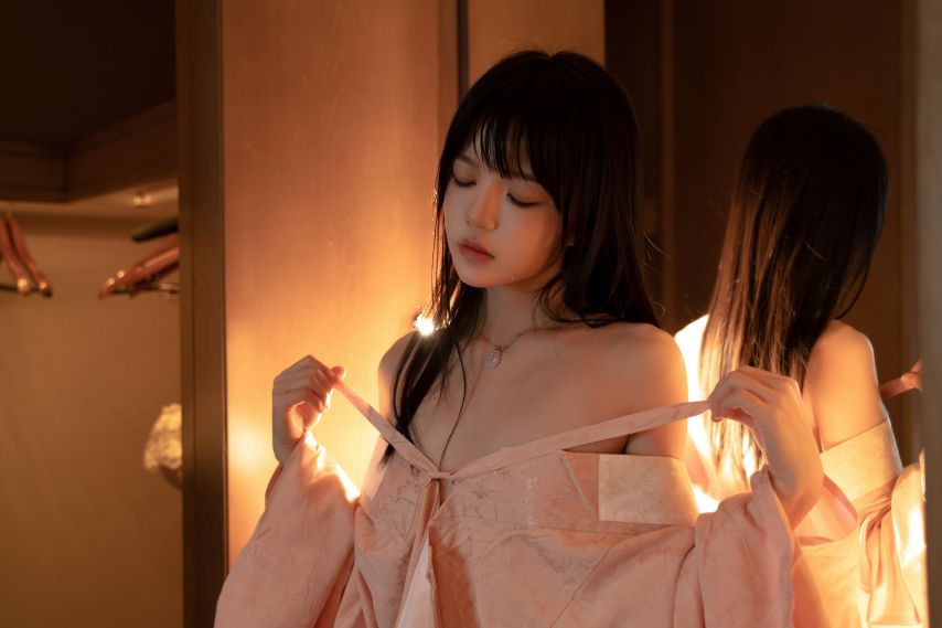 女人穿着粉红色的衬衫和粉红色的裙子。