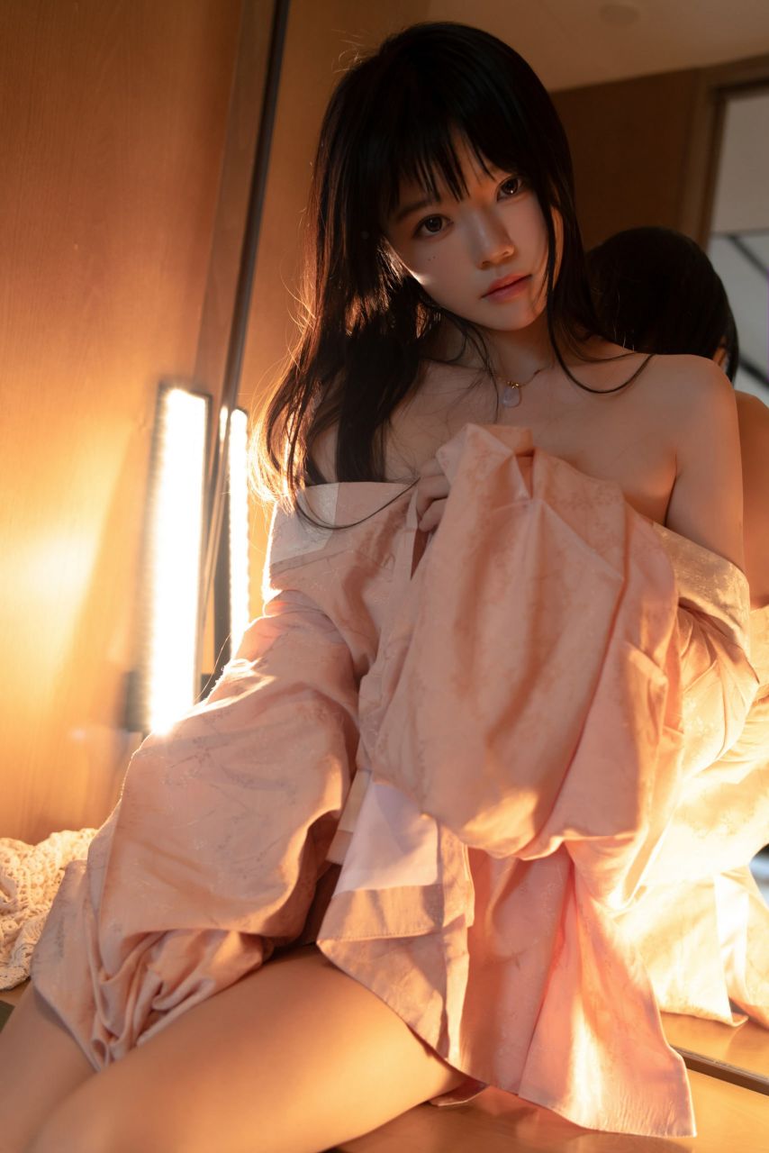 女人穿着粉红色的衬衫和粉红色的裙子。