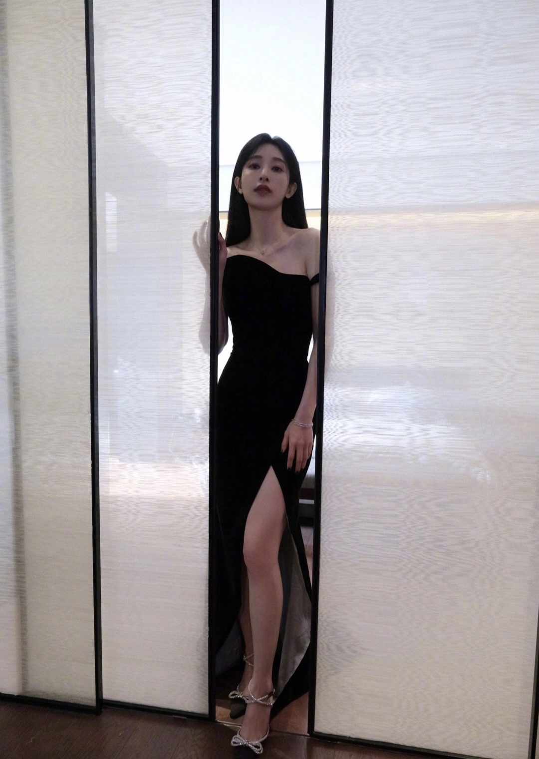 穿着黑色衣服的女人站在一个滑动的门前。