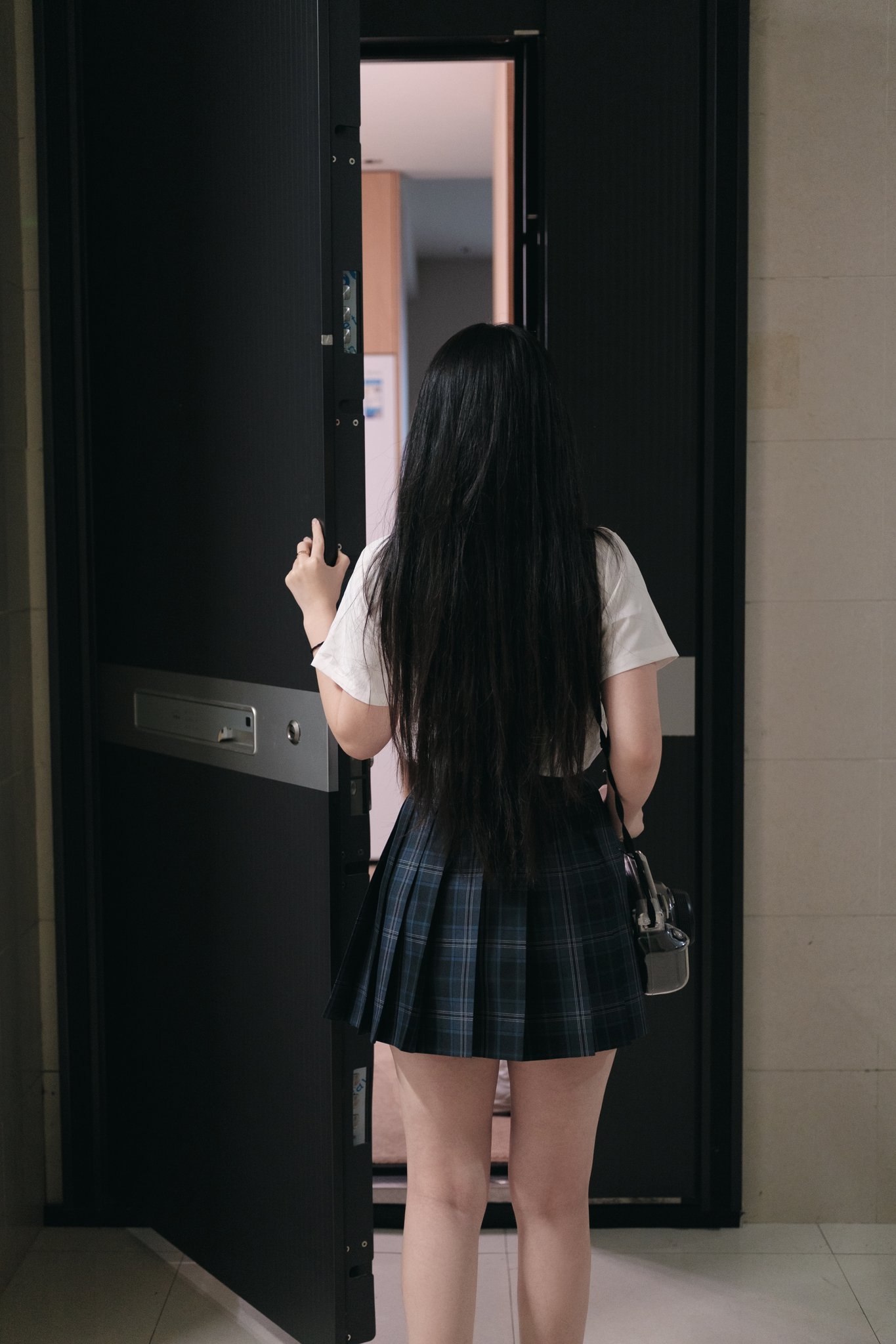 长头发和裙子的女人站在门口。