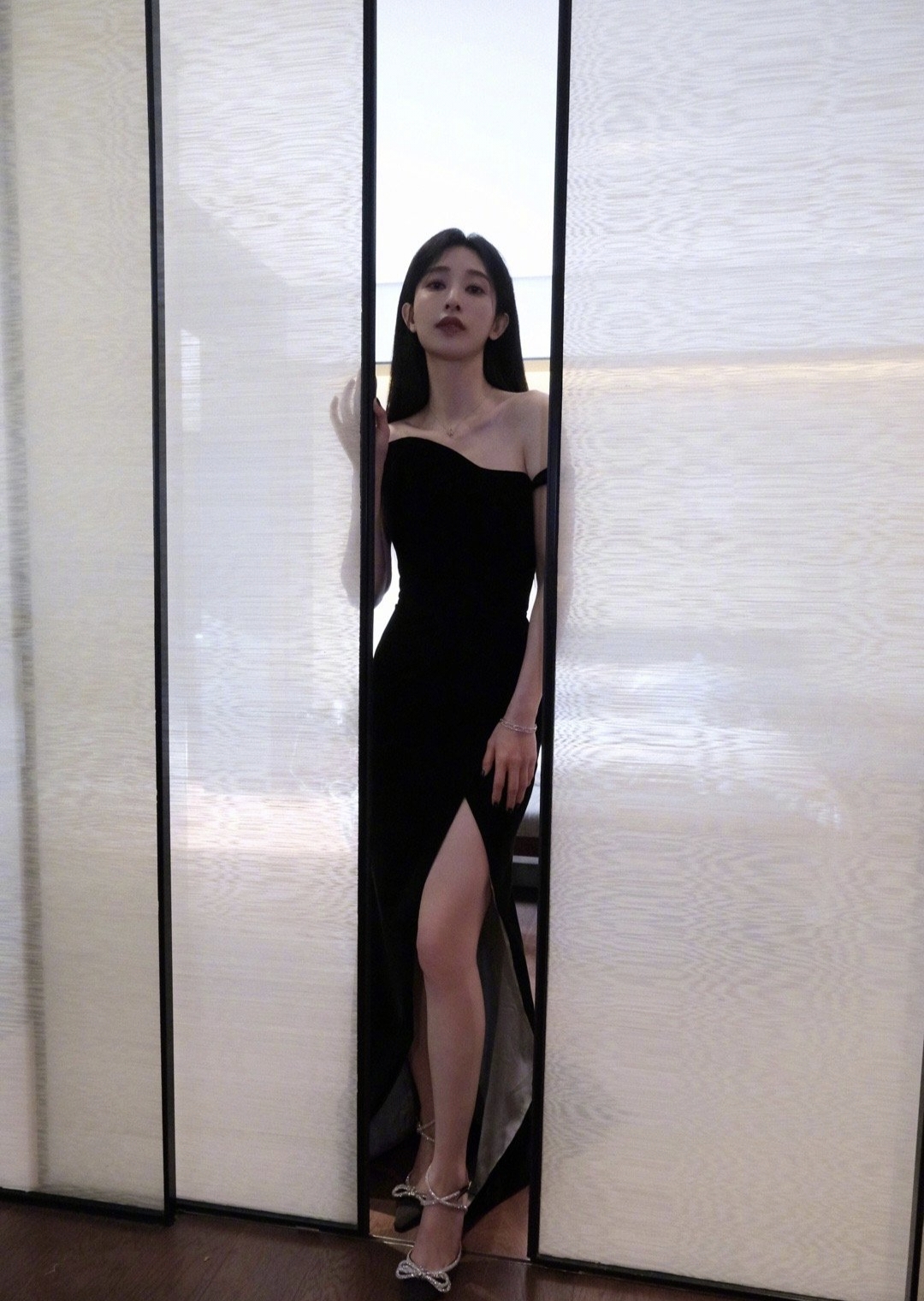 穿着黑色衣服的女人站在一个滑动的门前。