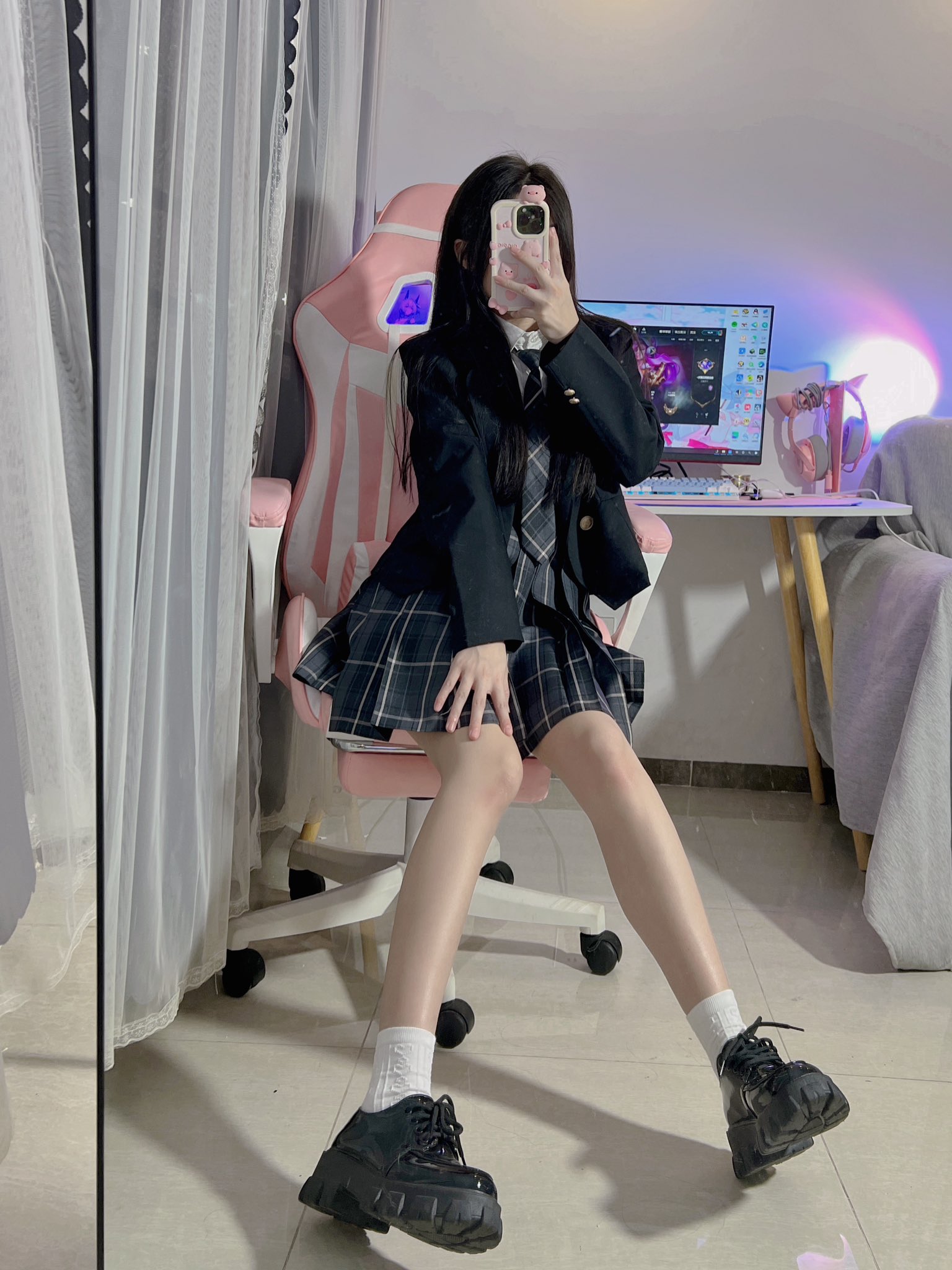 一名穿着学校制服的女孩在电脑前拍自拍。