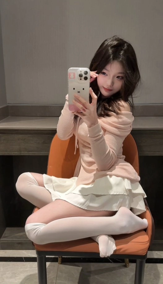 穿着粉红色衣服的女人用手机拍自拍。