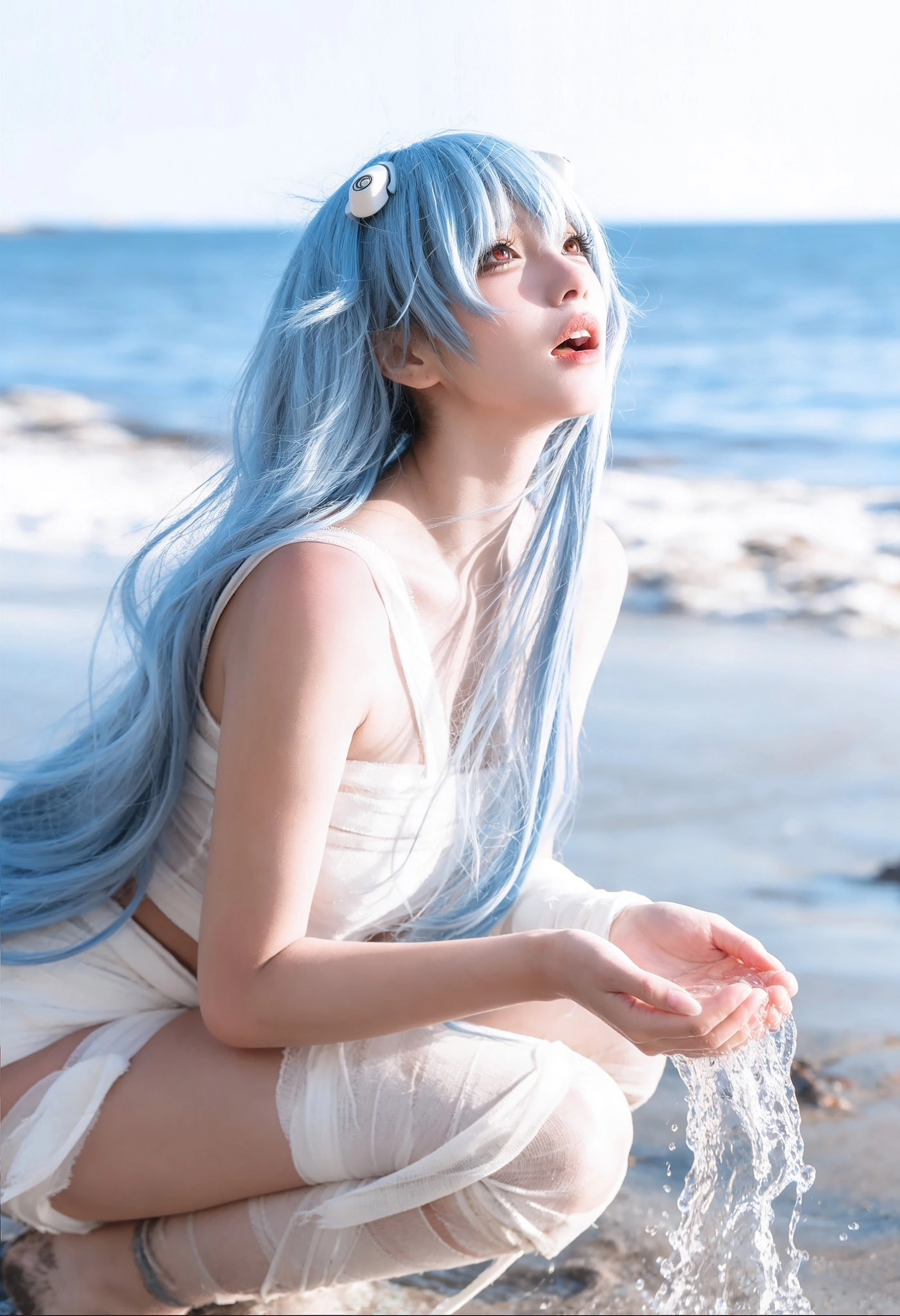 蓝头发的女人坐在海滩上。