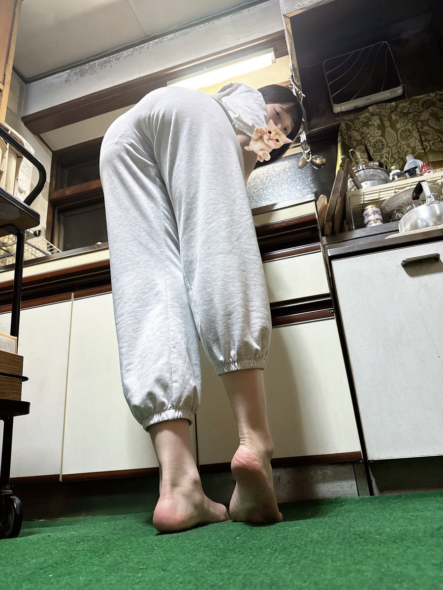 穿灰色裤子的女人站在厨房里。