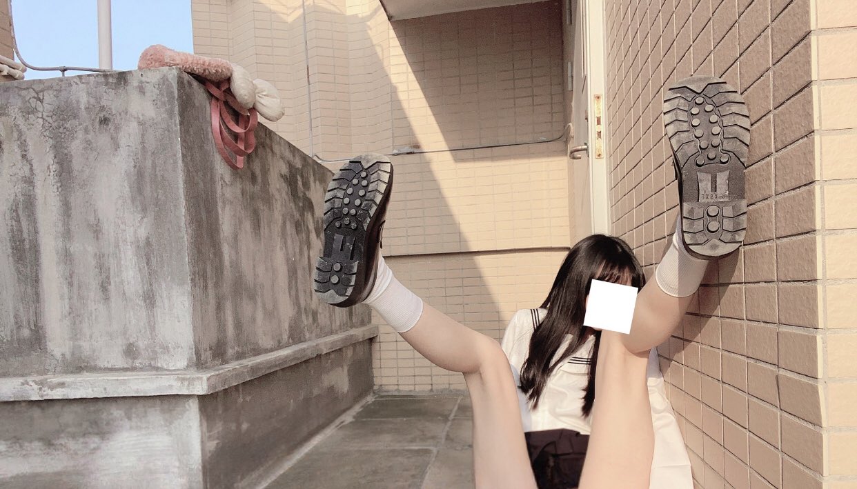 穿着黑色裙子和白色袜子的女孩在窗外挂着。