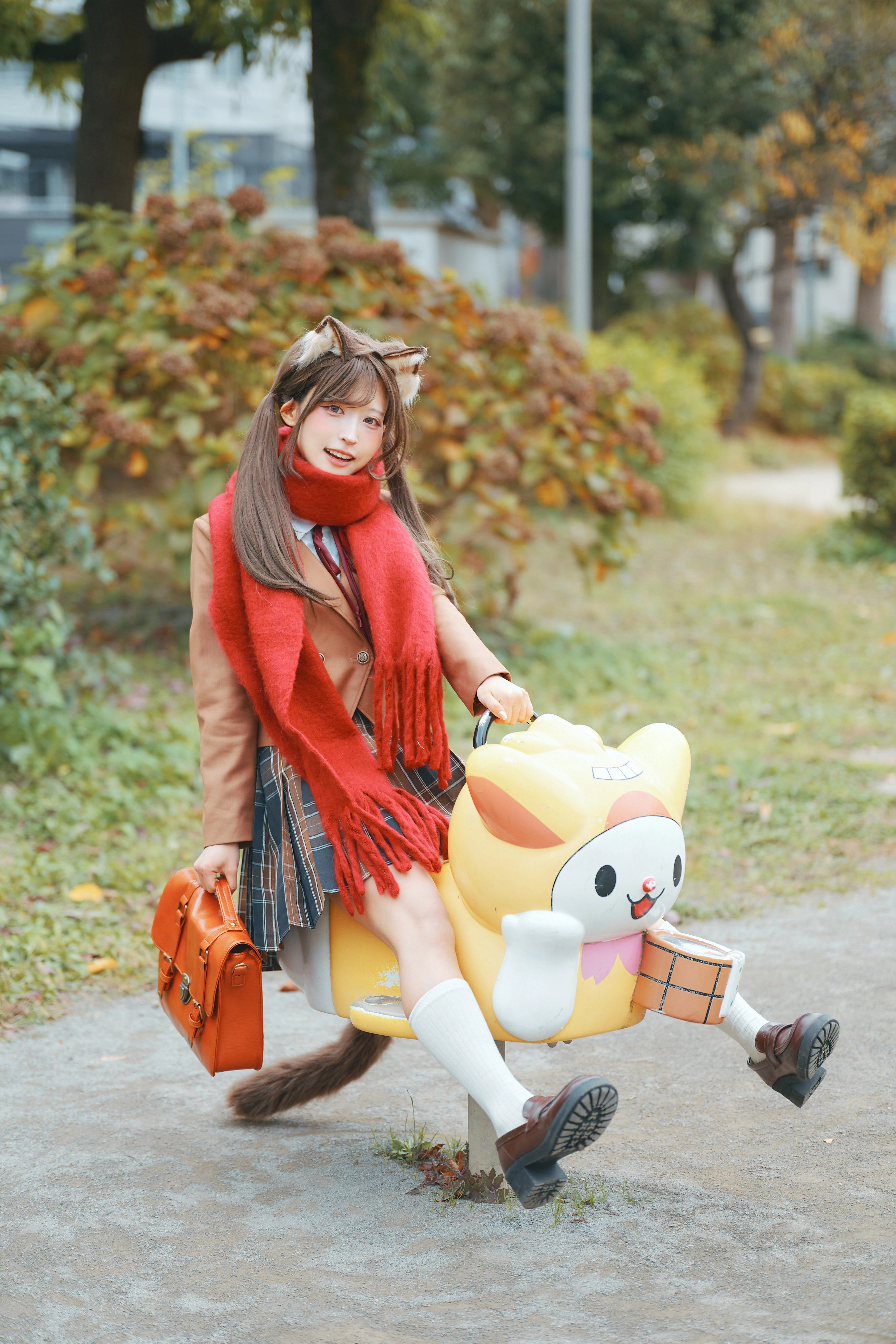 穿着学校制服的女孩骑着一个Hello Kitty的行李箱。