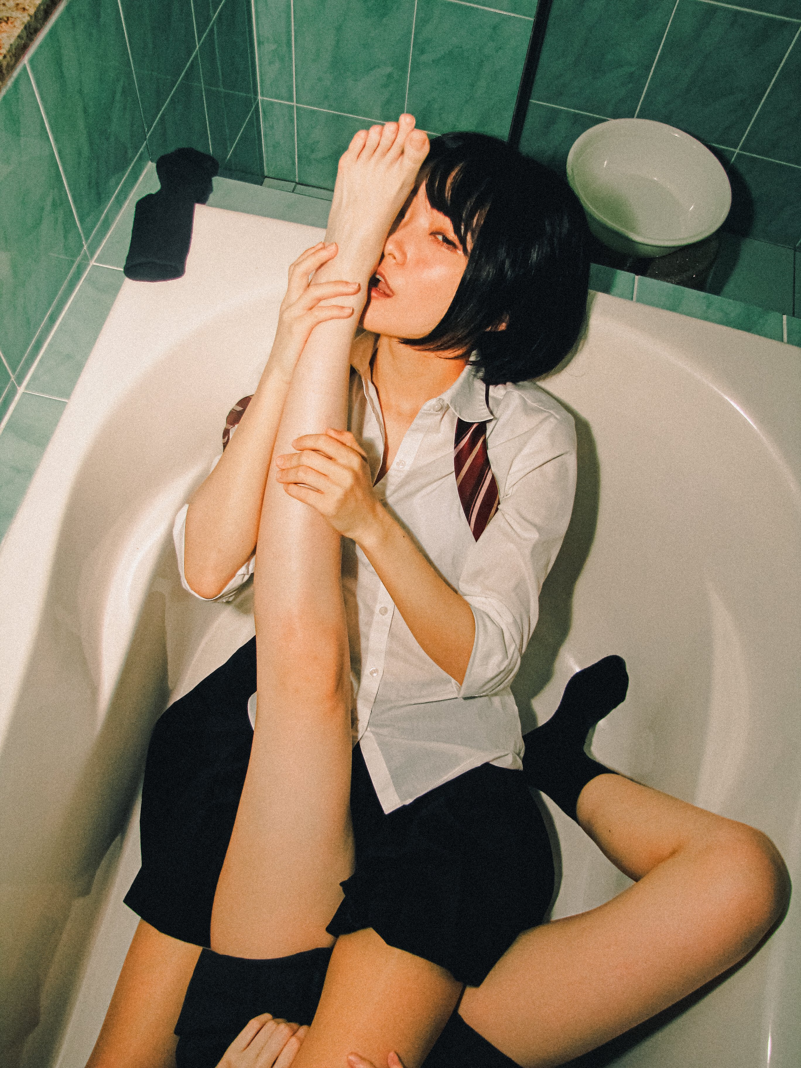 两个女孩在浴缸里,带着红领带。