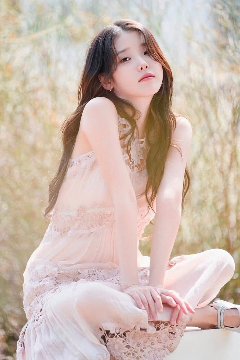 穿着粉红色衣服的女人坐在草地上。