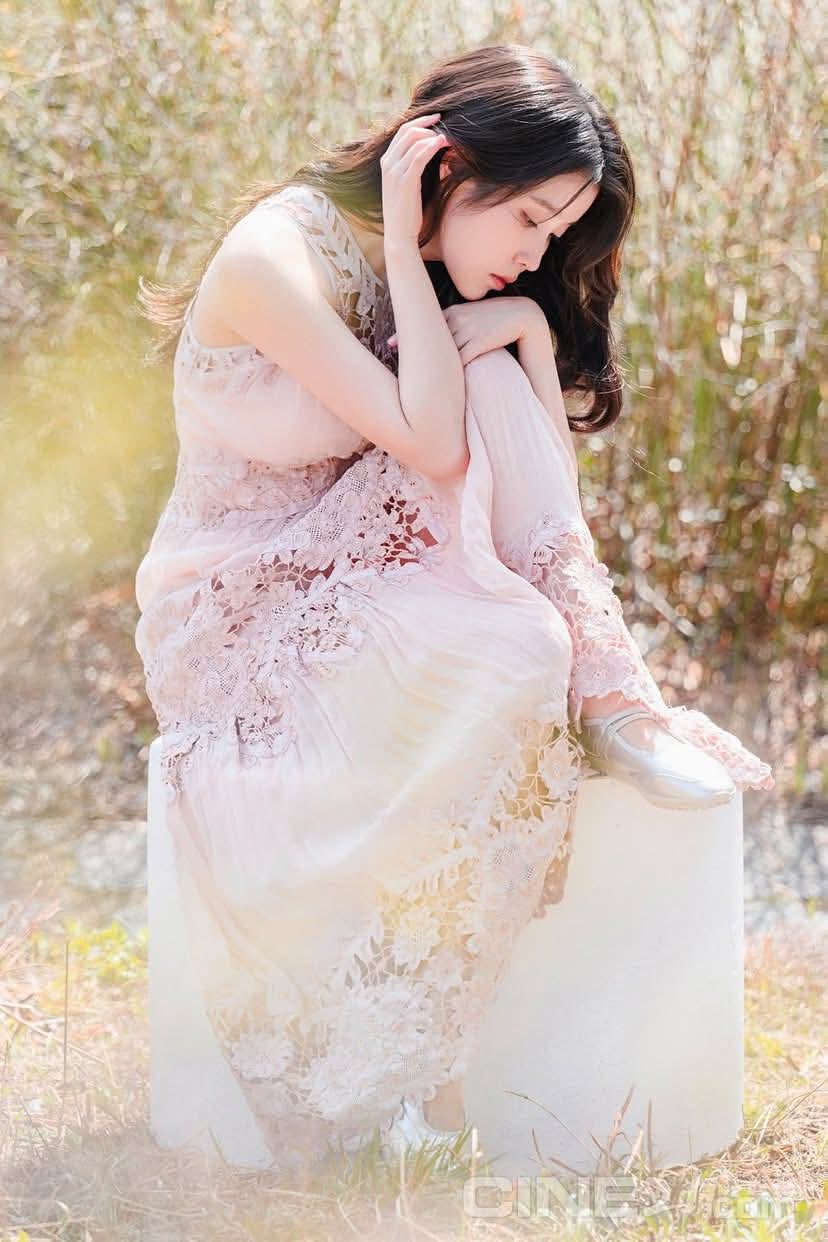 穿着粉红色衣服的女人坐在草地上。