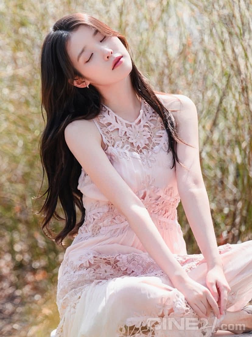 穿着粉红色衣服的女人坐在草地上。