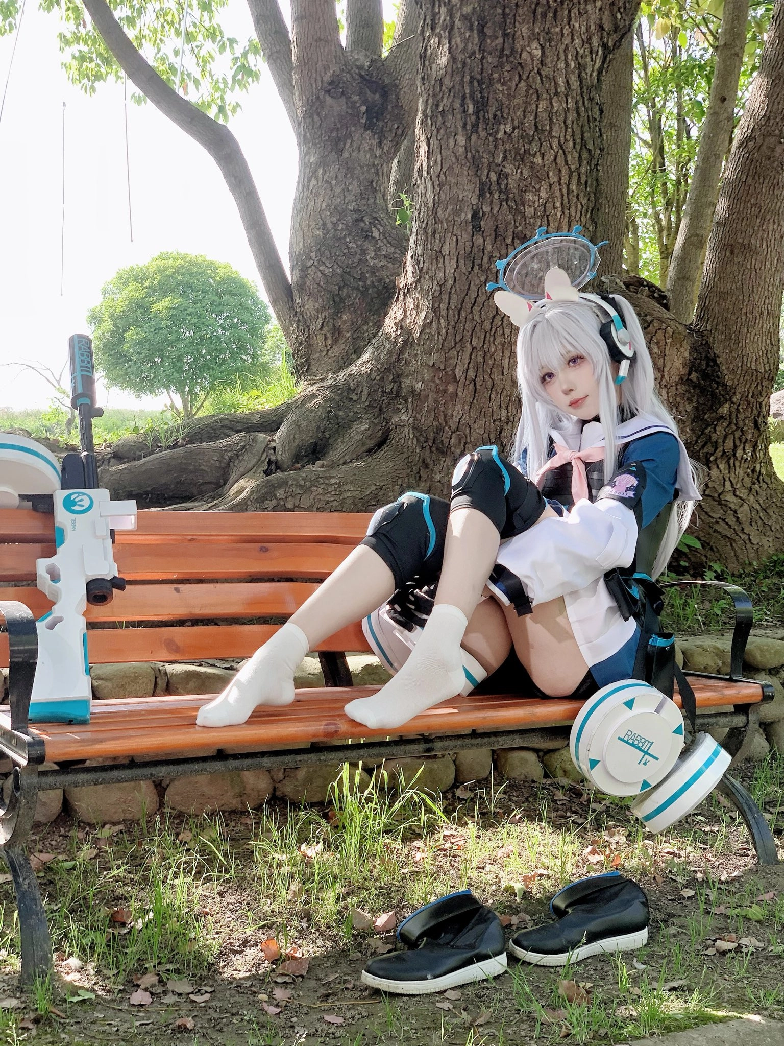 女人坐在一个凳子上,膝盖上有一把枪。