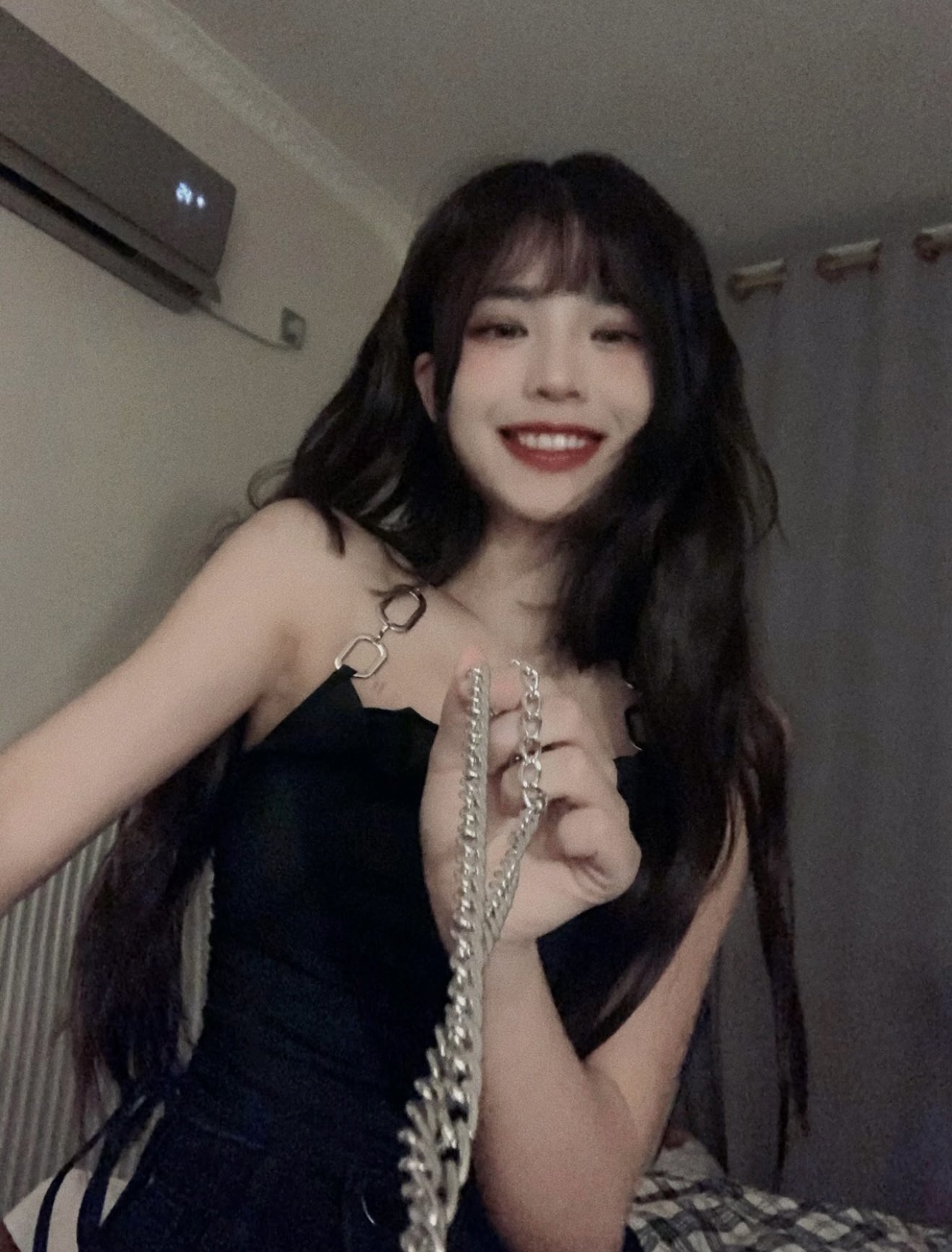 女人穿着黑色裙子,拿着项链。