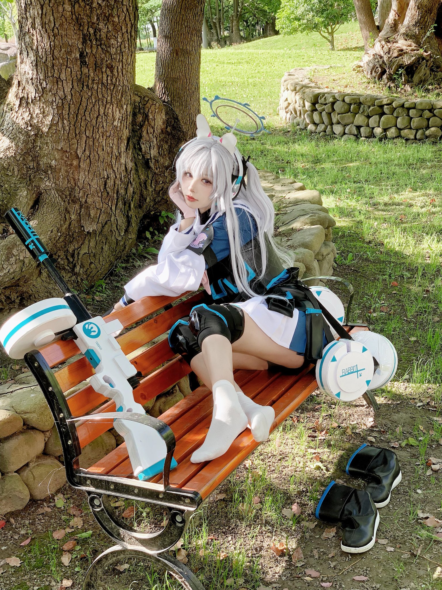 女人坐在一个凳子上,膝盖上有一把枪。