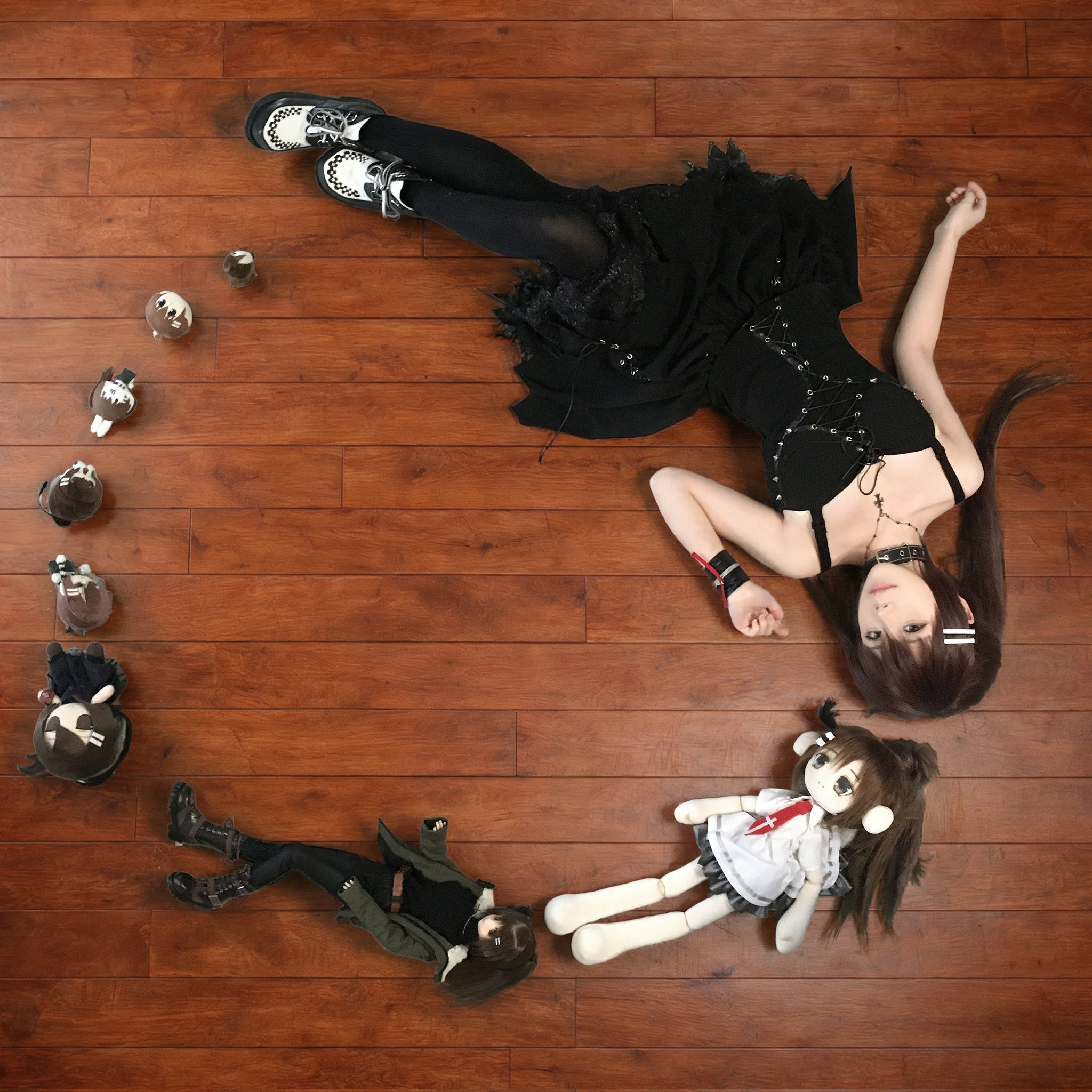 女人躺在地板上,带着一个娃娃和一个杯子。