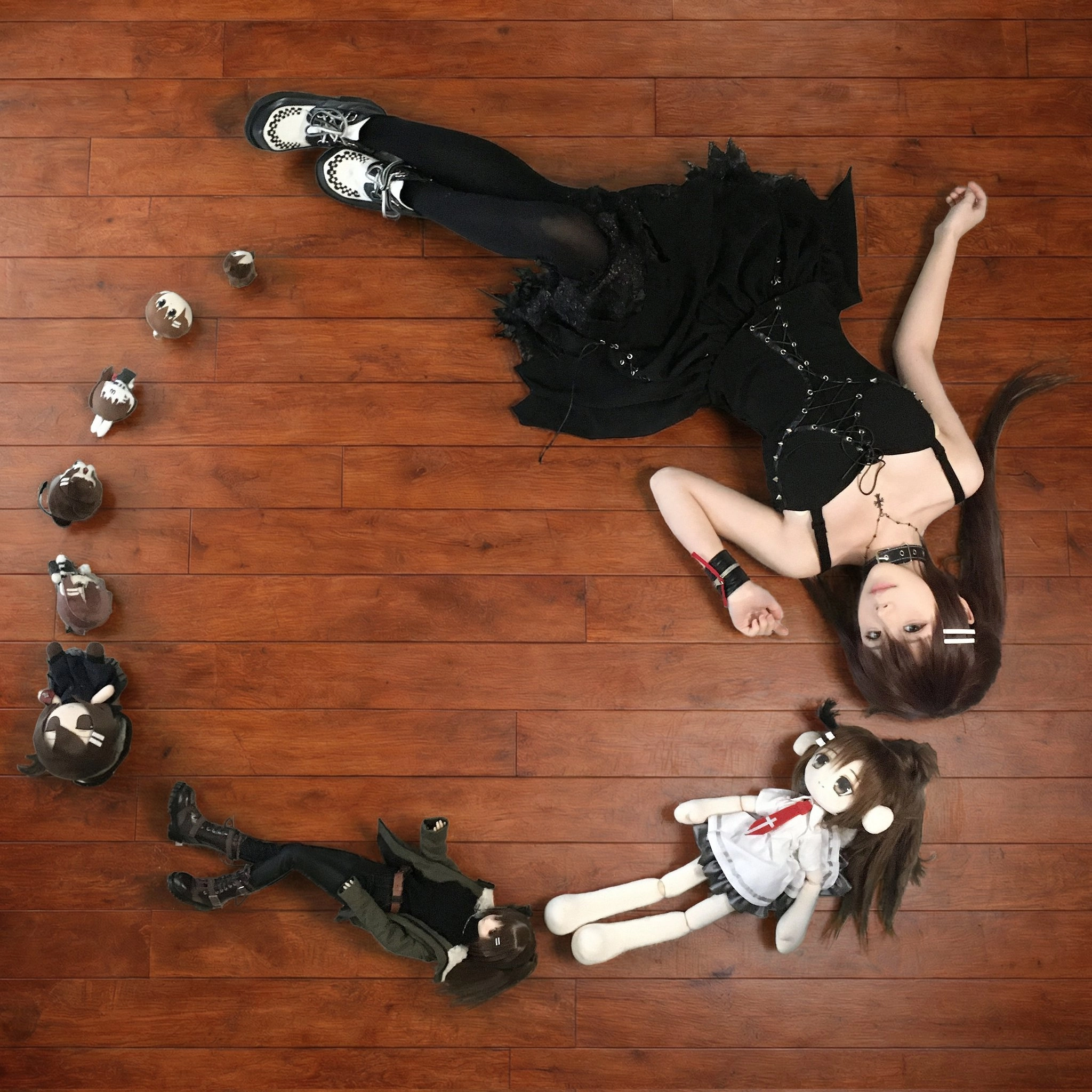 女人躺在地板上,带着一个娃娃和一个杯子。