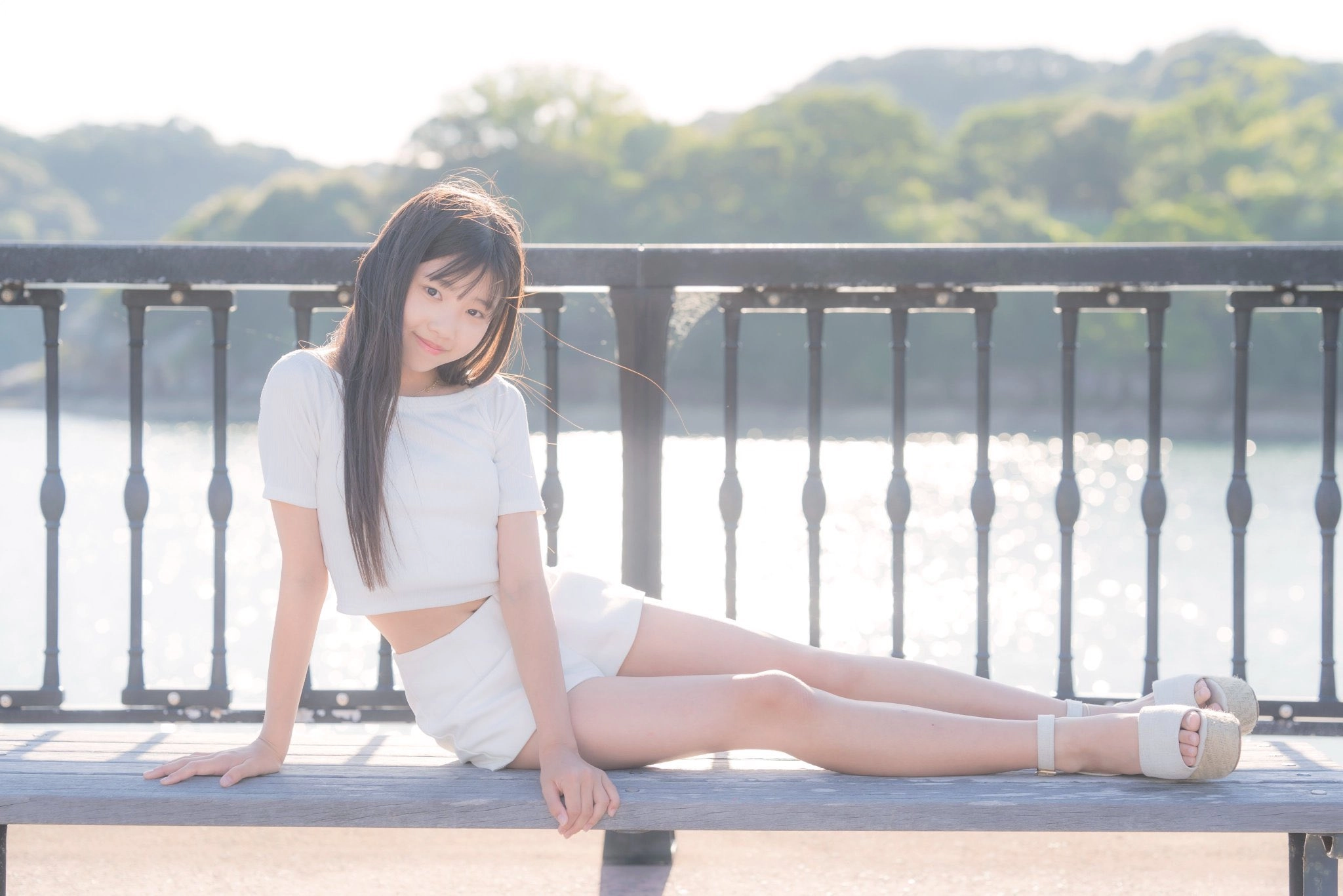 穿着白色衬衫和短裤的女人坐在一个凳子上。