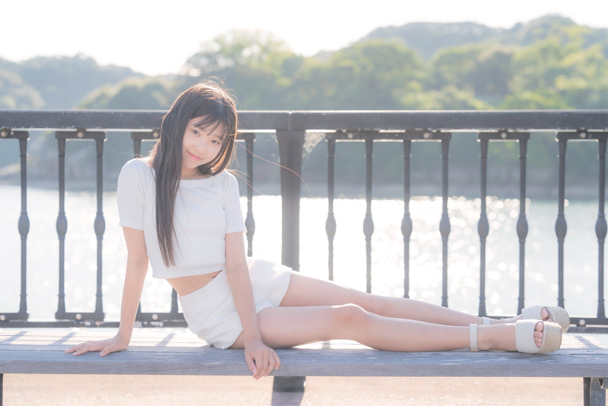 穿着白色衬衫和短裤的女人坐在一个凳子上。