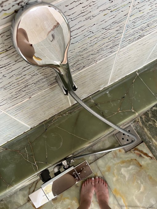 人的脚在浴室镜子的反射中可见。