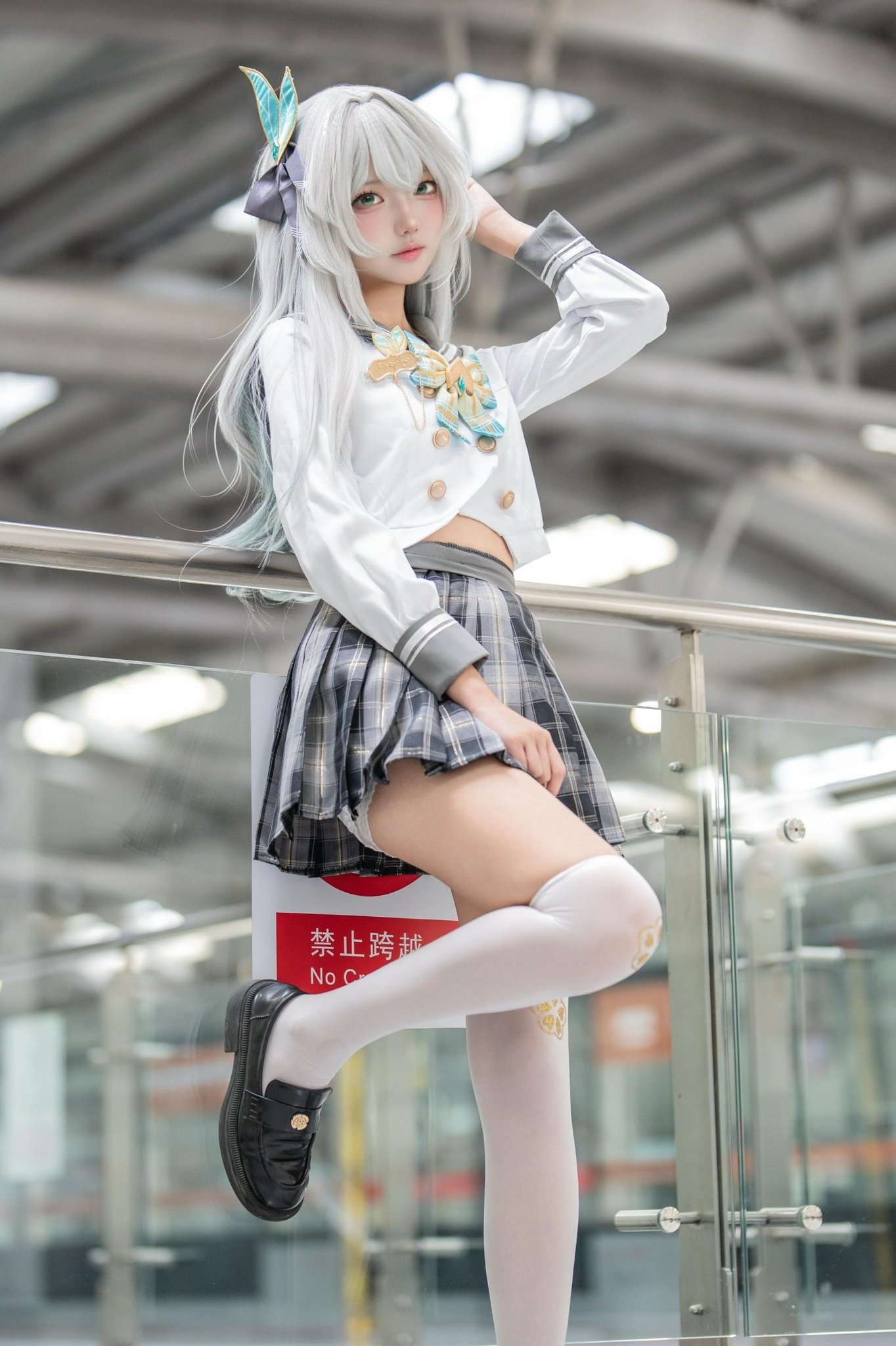 一位穿着白色外套和黑色裙子的女人站在楼梯上。