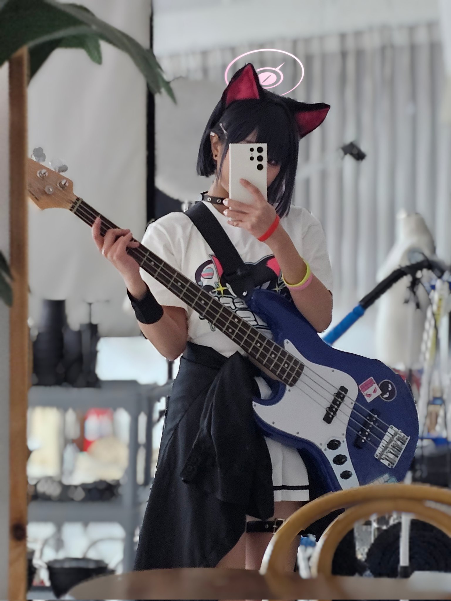一位戴着猫耳带的女孩带着吉他拍自拍。
