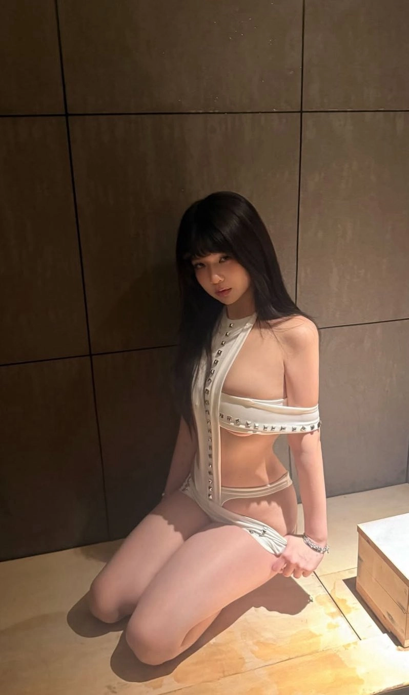 女人穿着一件白色的裙子,脖子上有一条链。