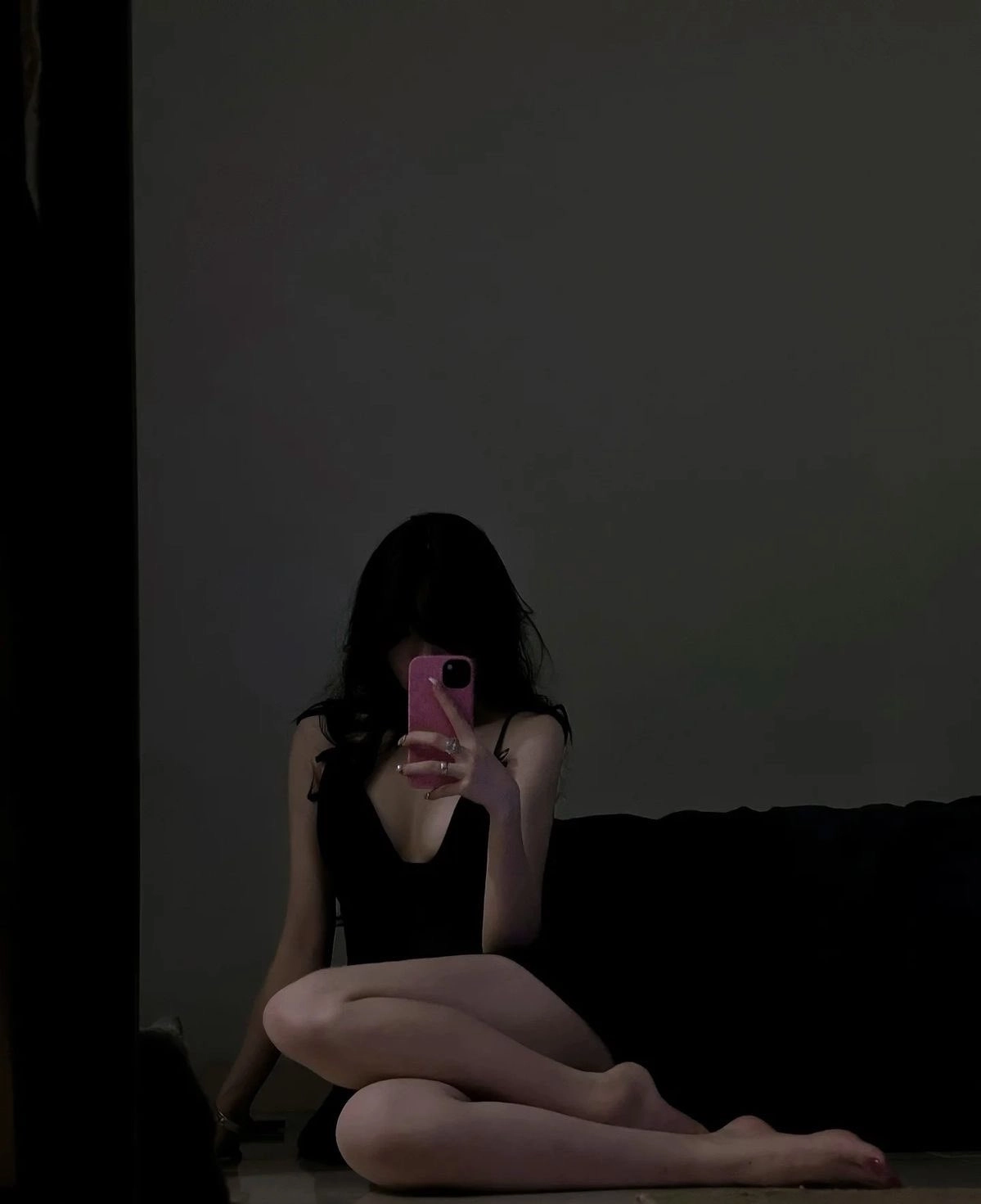 女人穿着黑色裙子拍自拍。