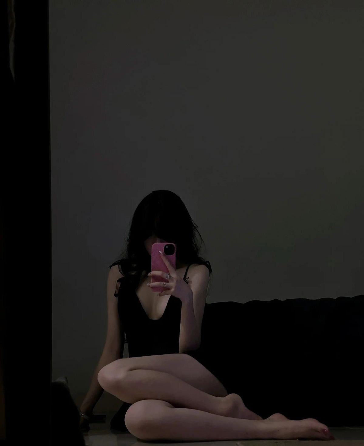 女人穿着黑色裙子拍自拍。