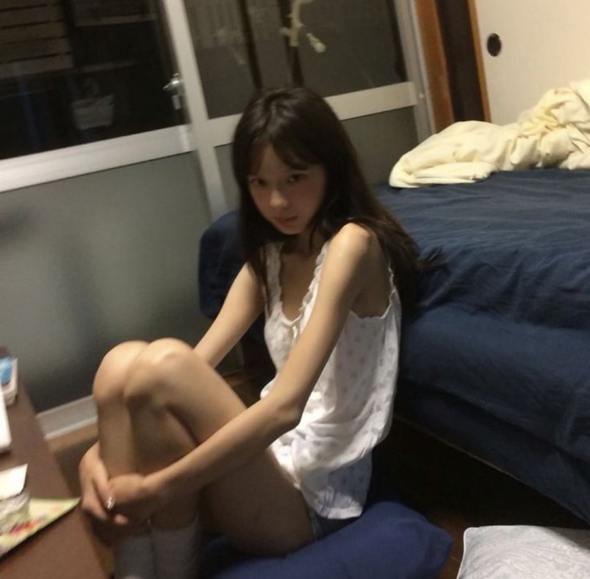 穿着白色衣服的女人坐在床上。