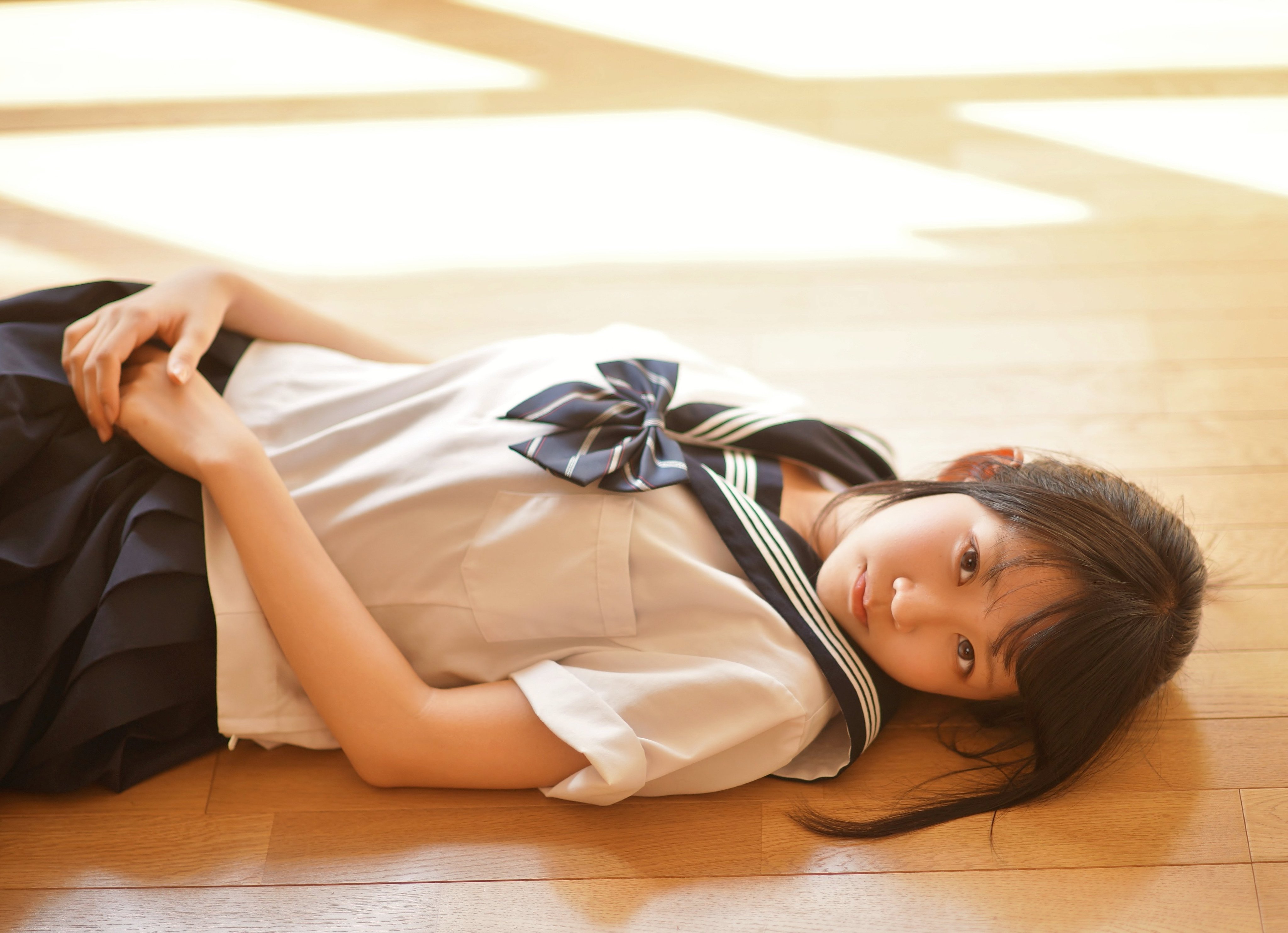 穿着蓝色弓巾的女孩躺在地板上。