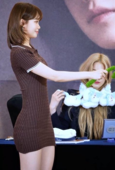 穿着棕色衣服的女人拿着一张绿叶。