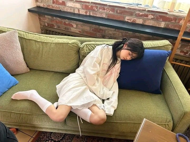 穿着白色衣服的女人睡在沙发上。