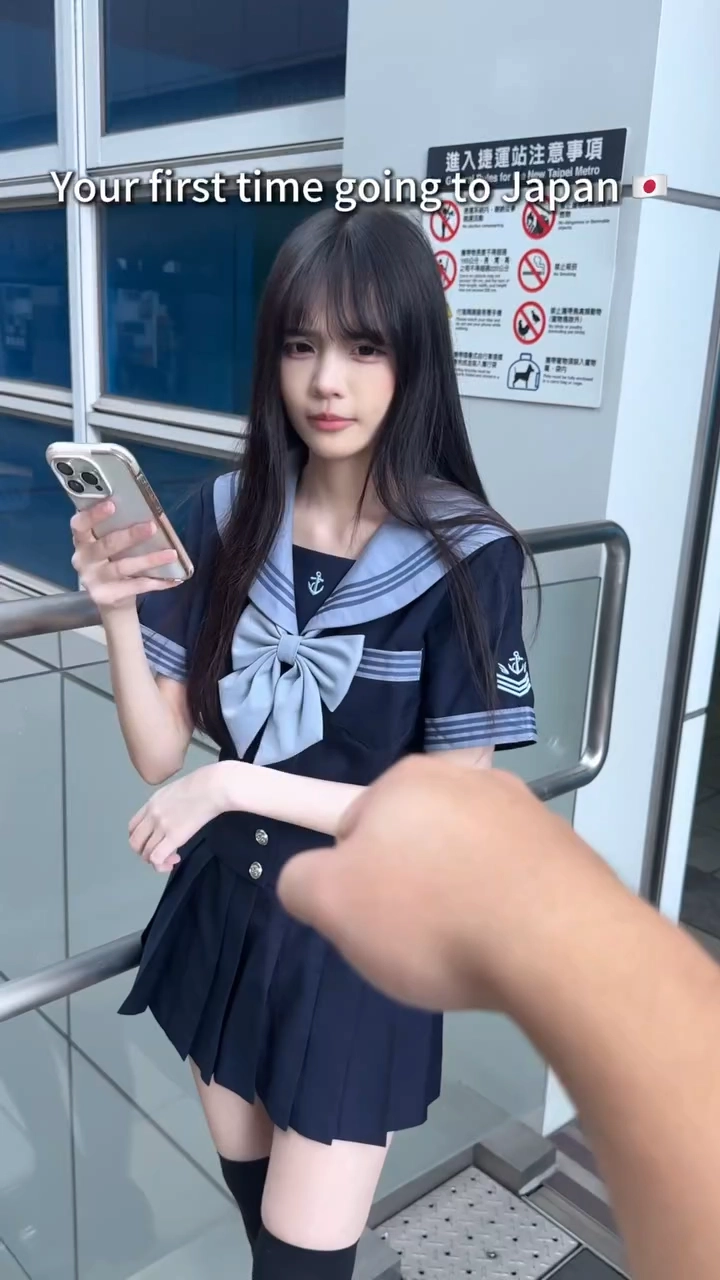 穿着蓝色弓和蓝色和白色水手的制服的女孩。