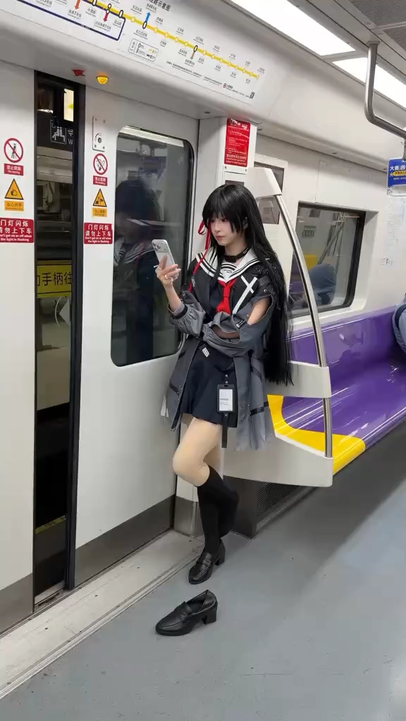 穿着水手服的女人看着她的手机。