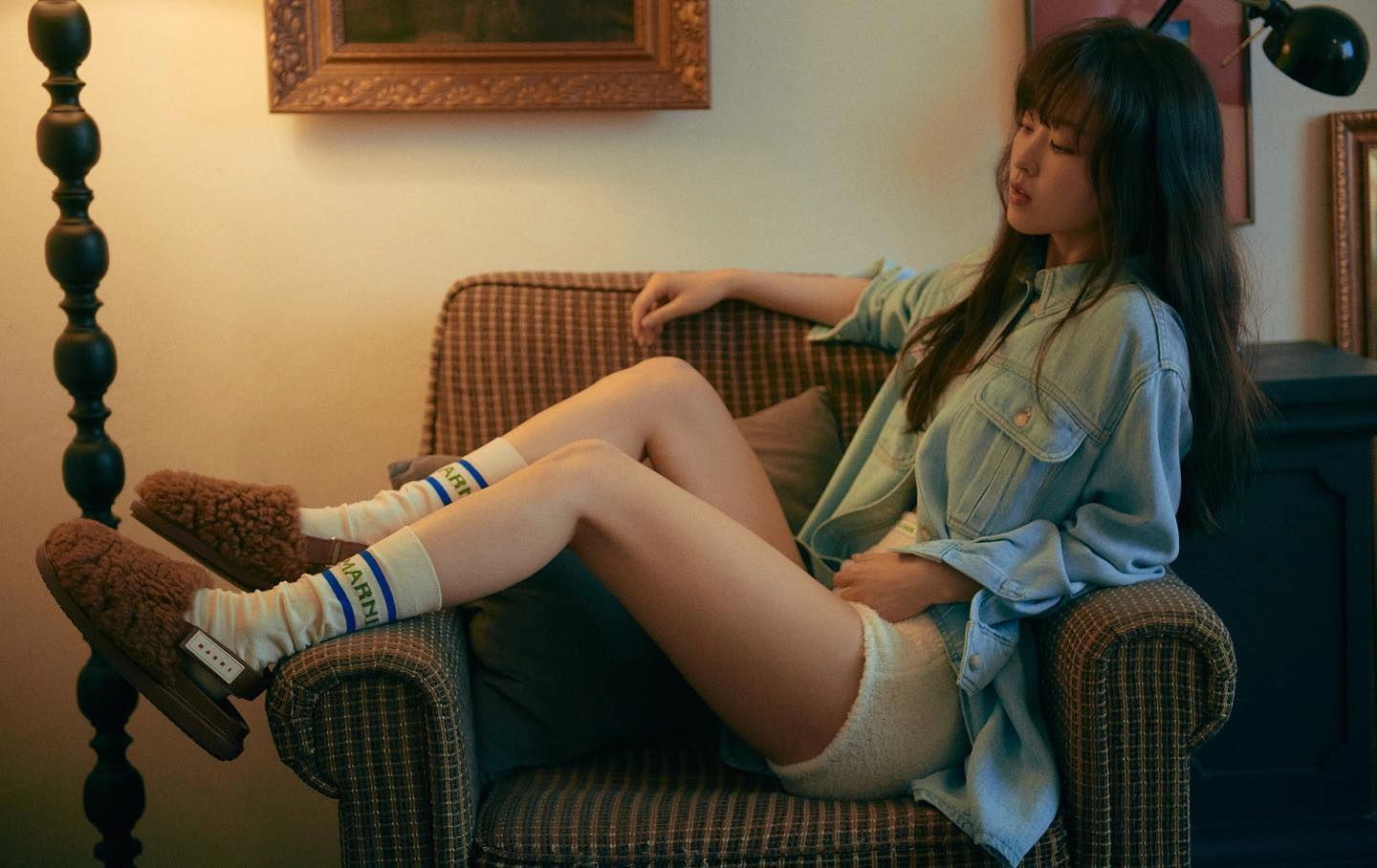 穿蓝色夹克的女人坐在沙发上。