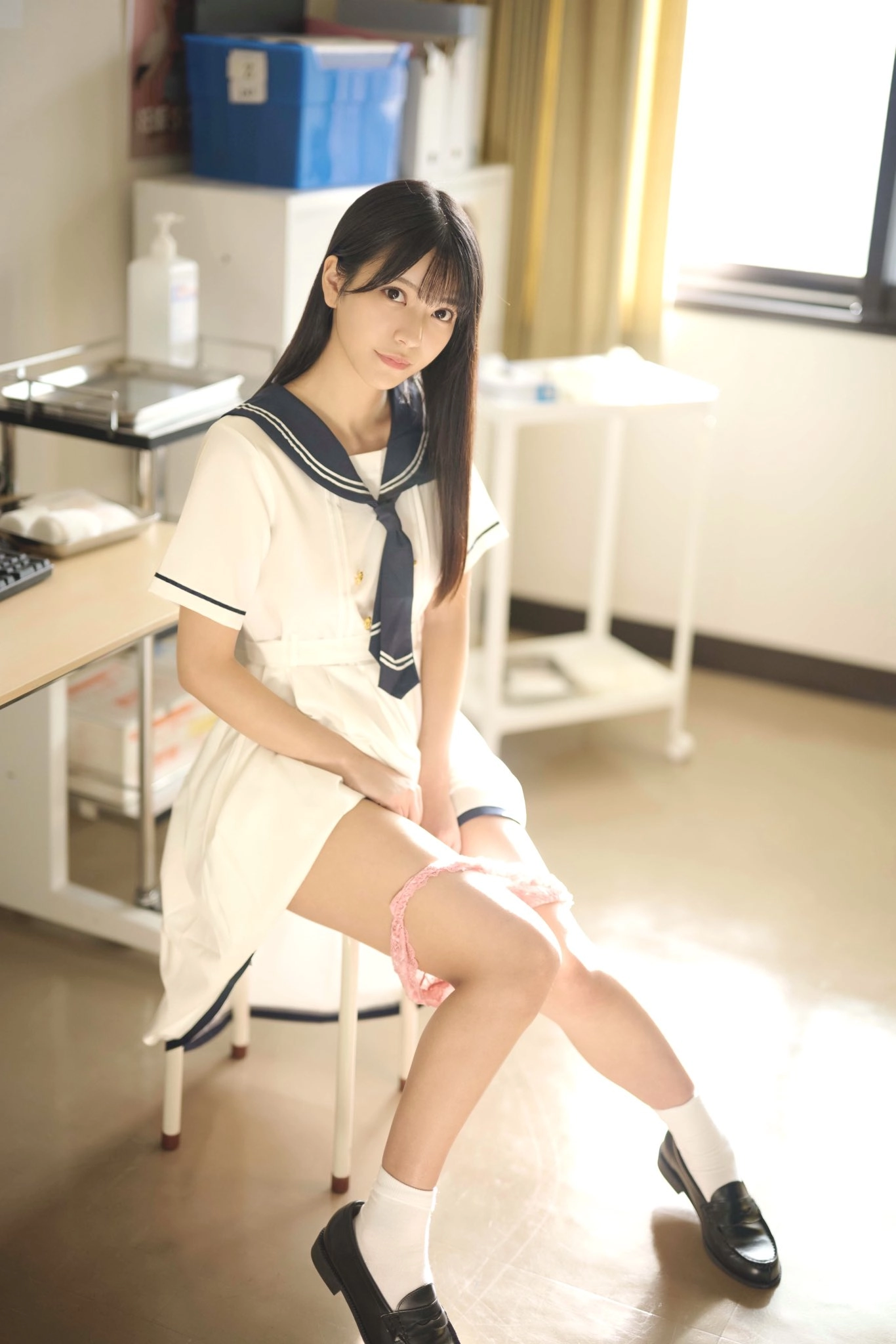 穿着白色裙子和蓝色领带的女人坐在椅子上。