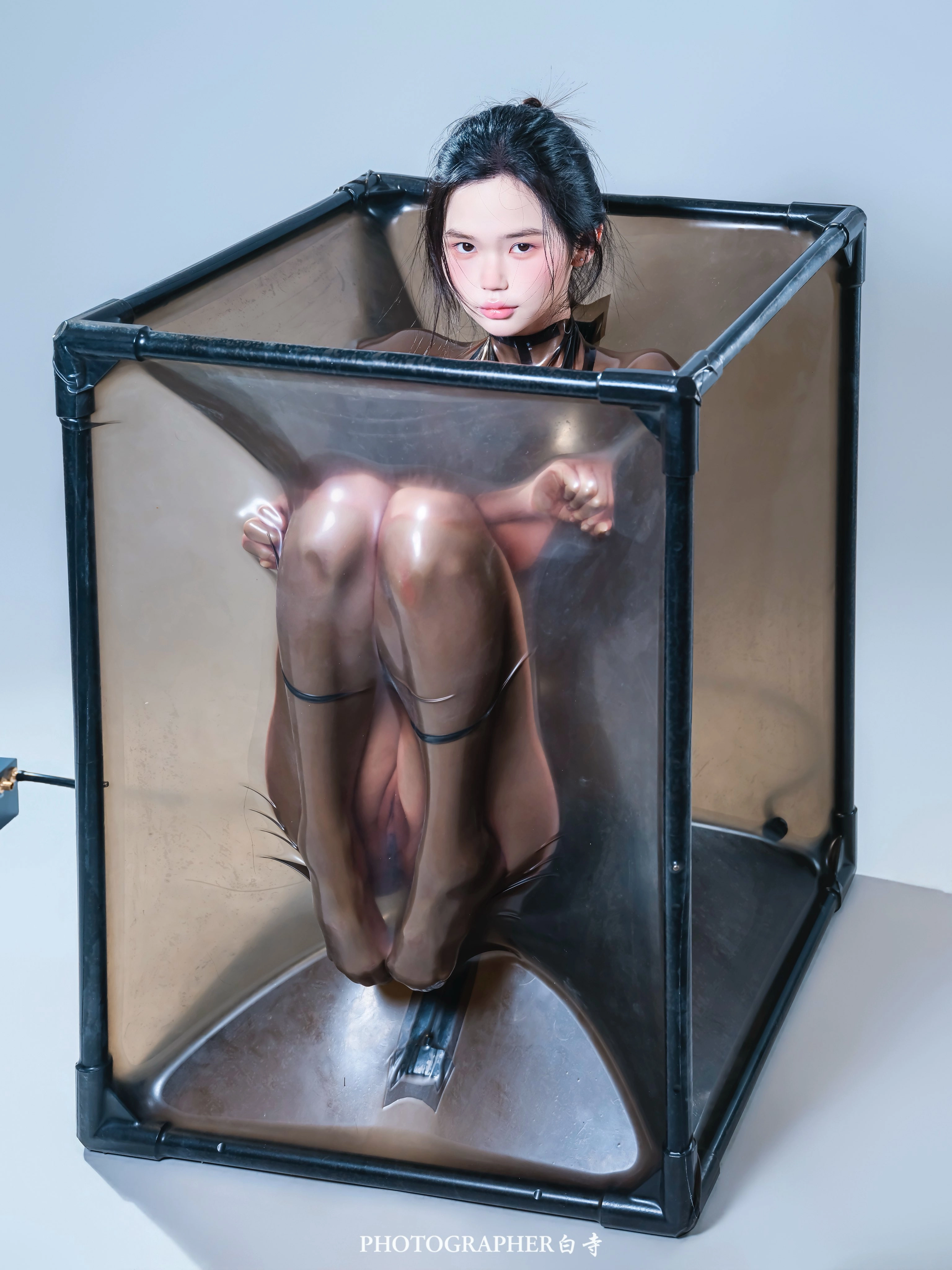 The woman sits in a metal box.