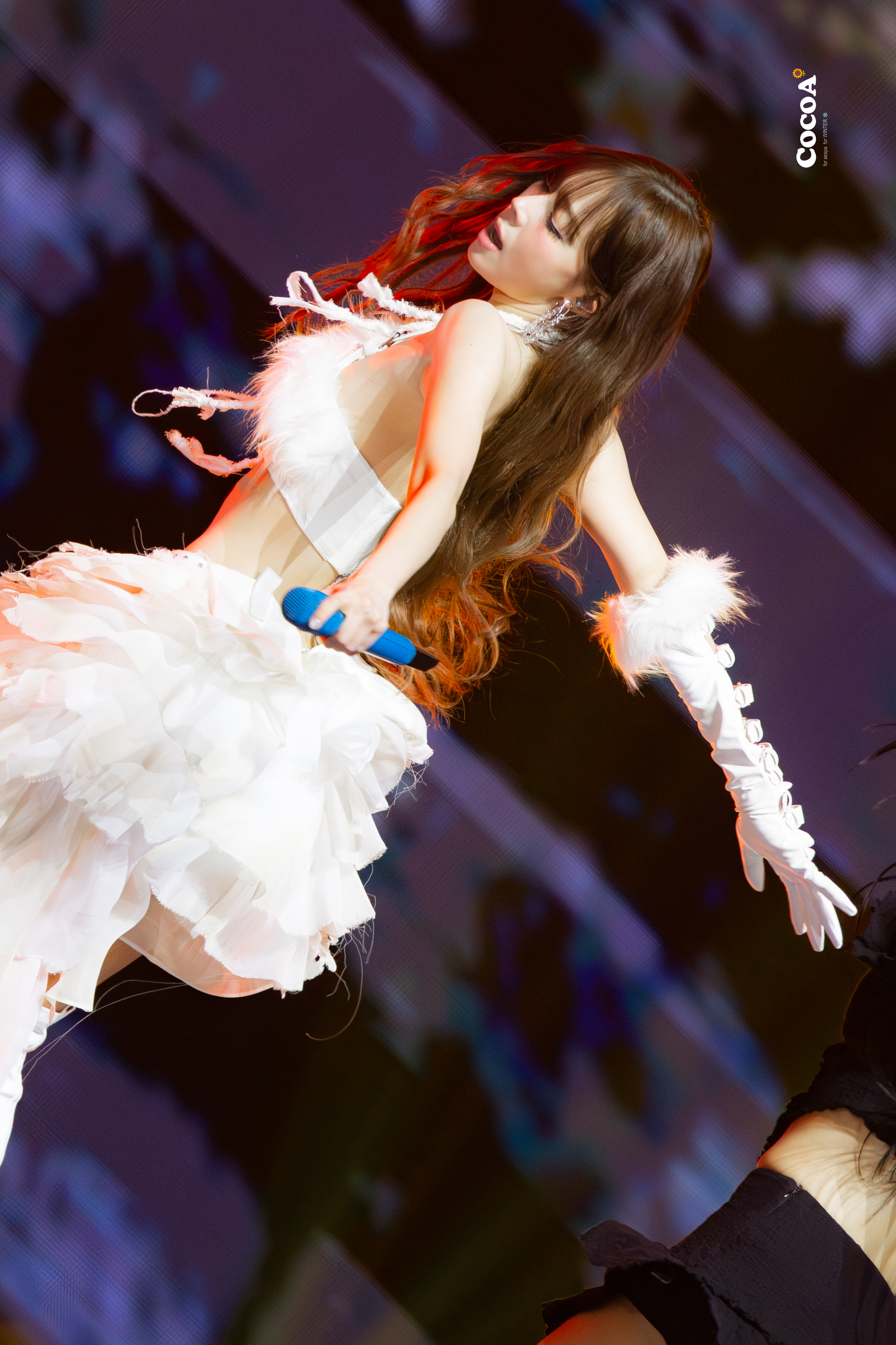 红头发和白衣的女人在舞台上表演。