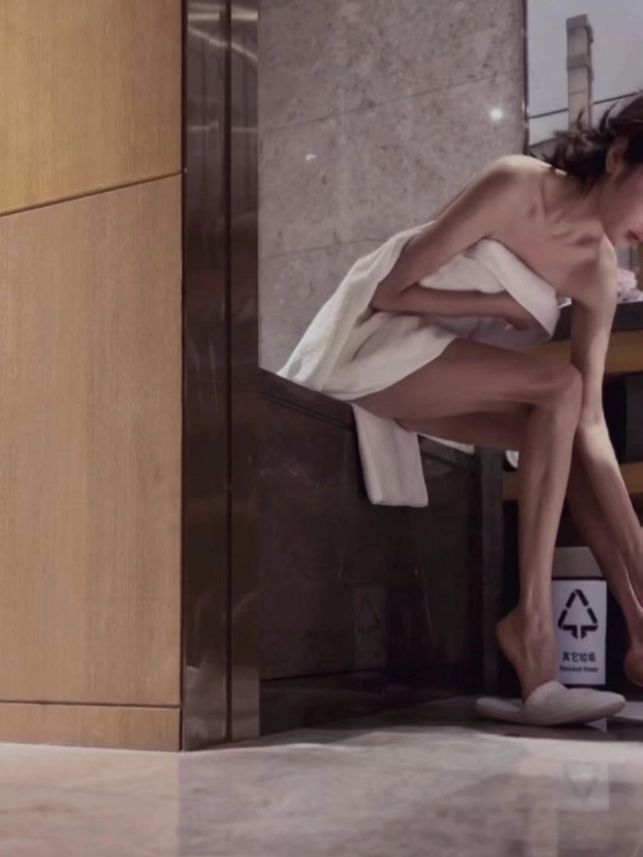 穿着白色衣服的女人坐在一个凳子上。