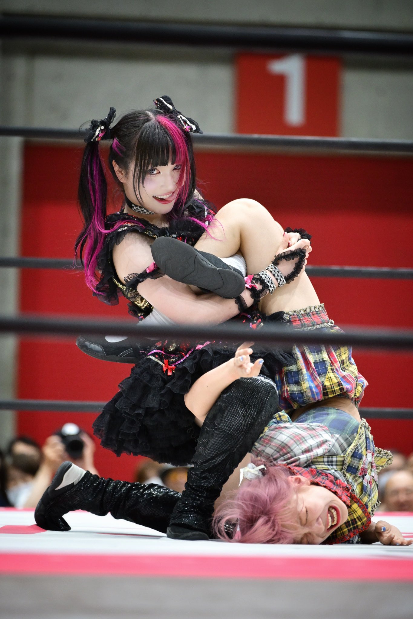 穿着黑色衣服的女孩被另一个女孩抱在头盔里。