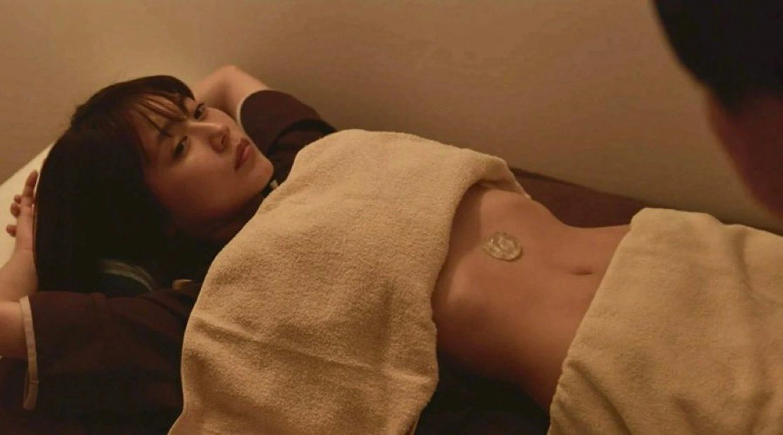 女人躺在床上,一件毛巾在她身上。