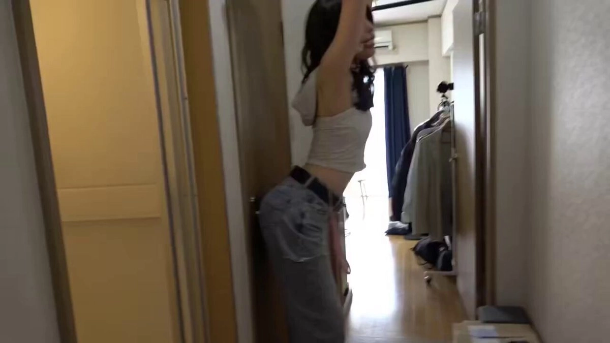 穿着白色坦克顶的女人挂在一扇门上。