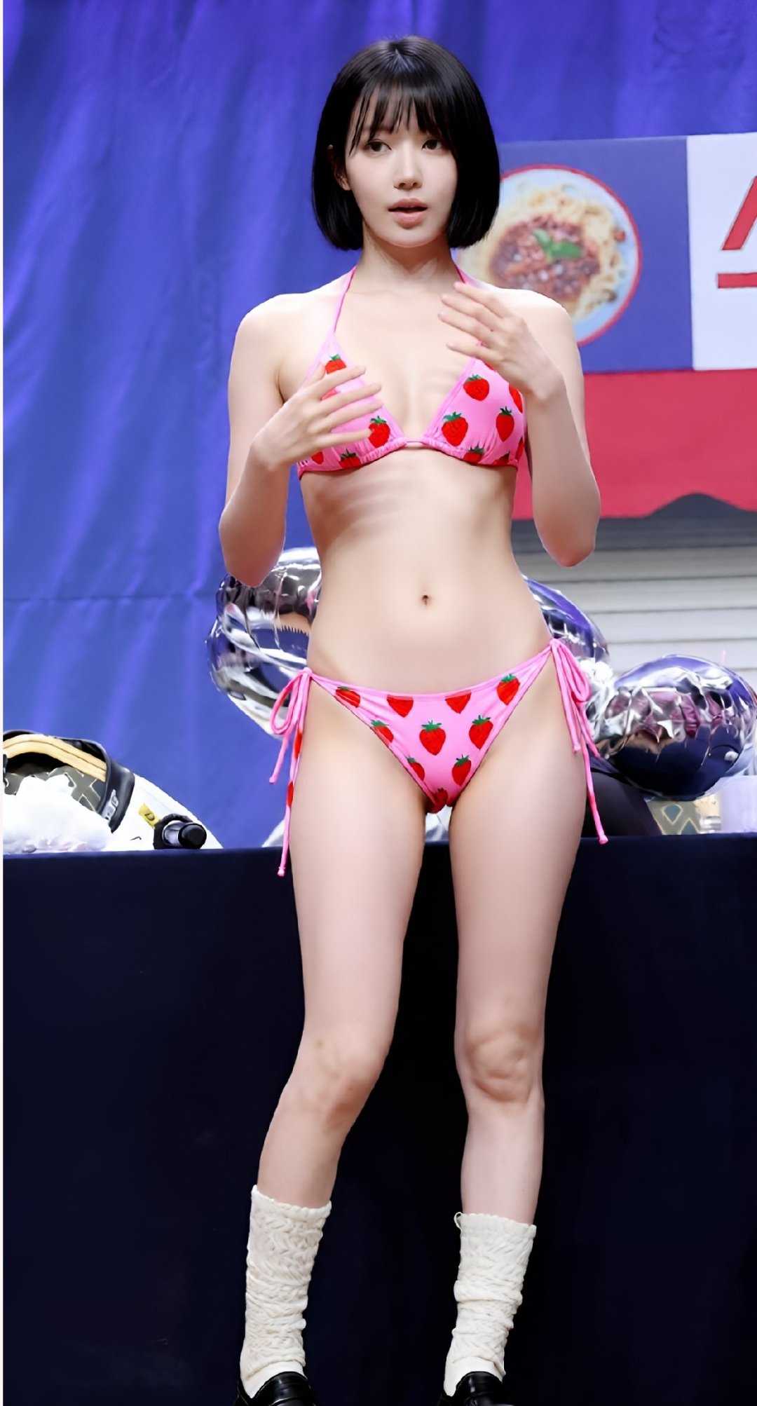 穿着粉红色比基尼的女人站在一张桌子上。