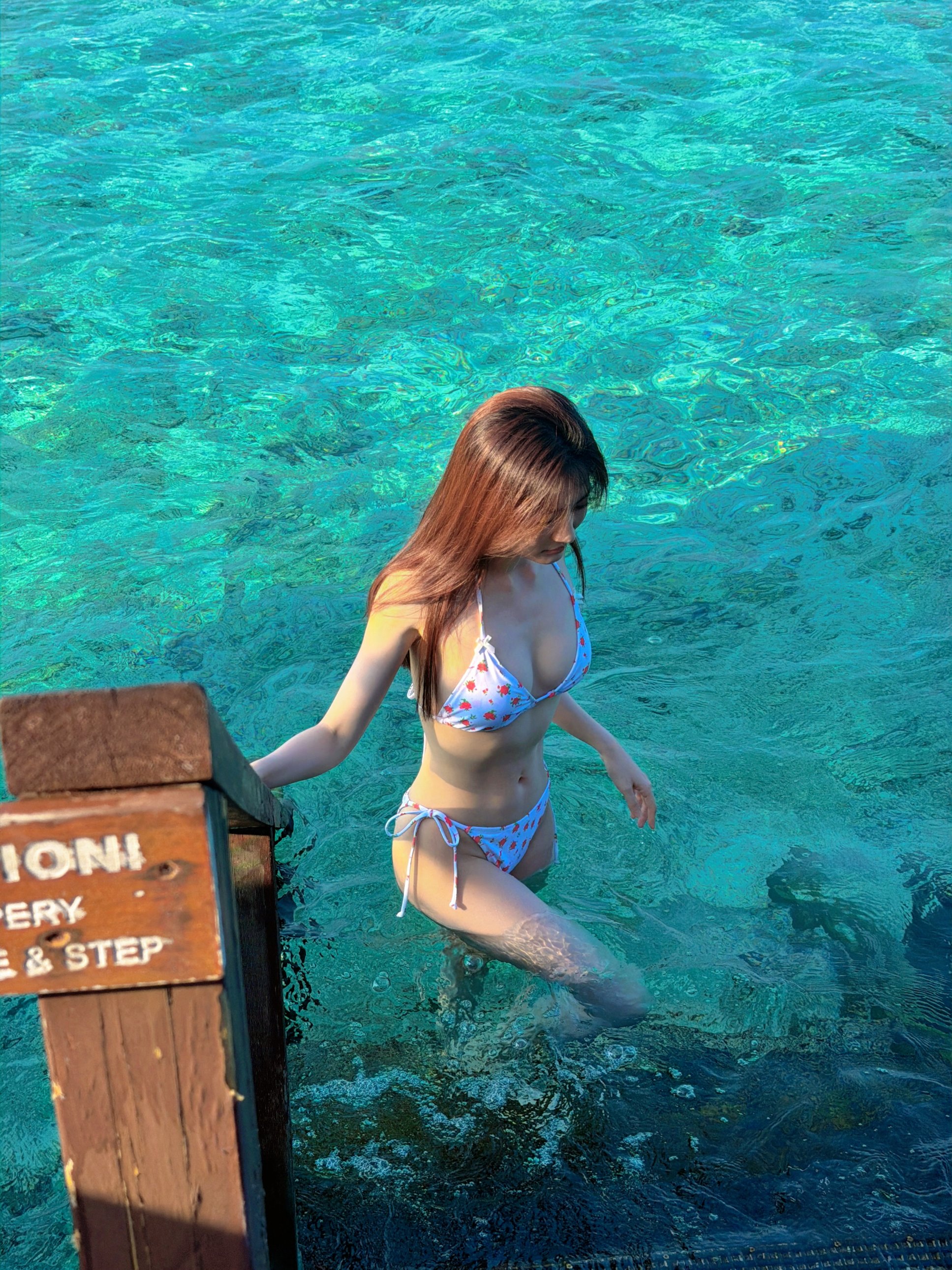 穿比基尼的女人站在水里。