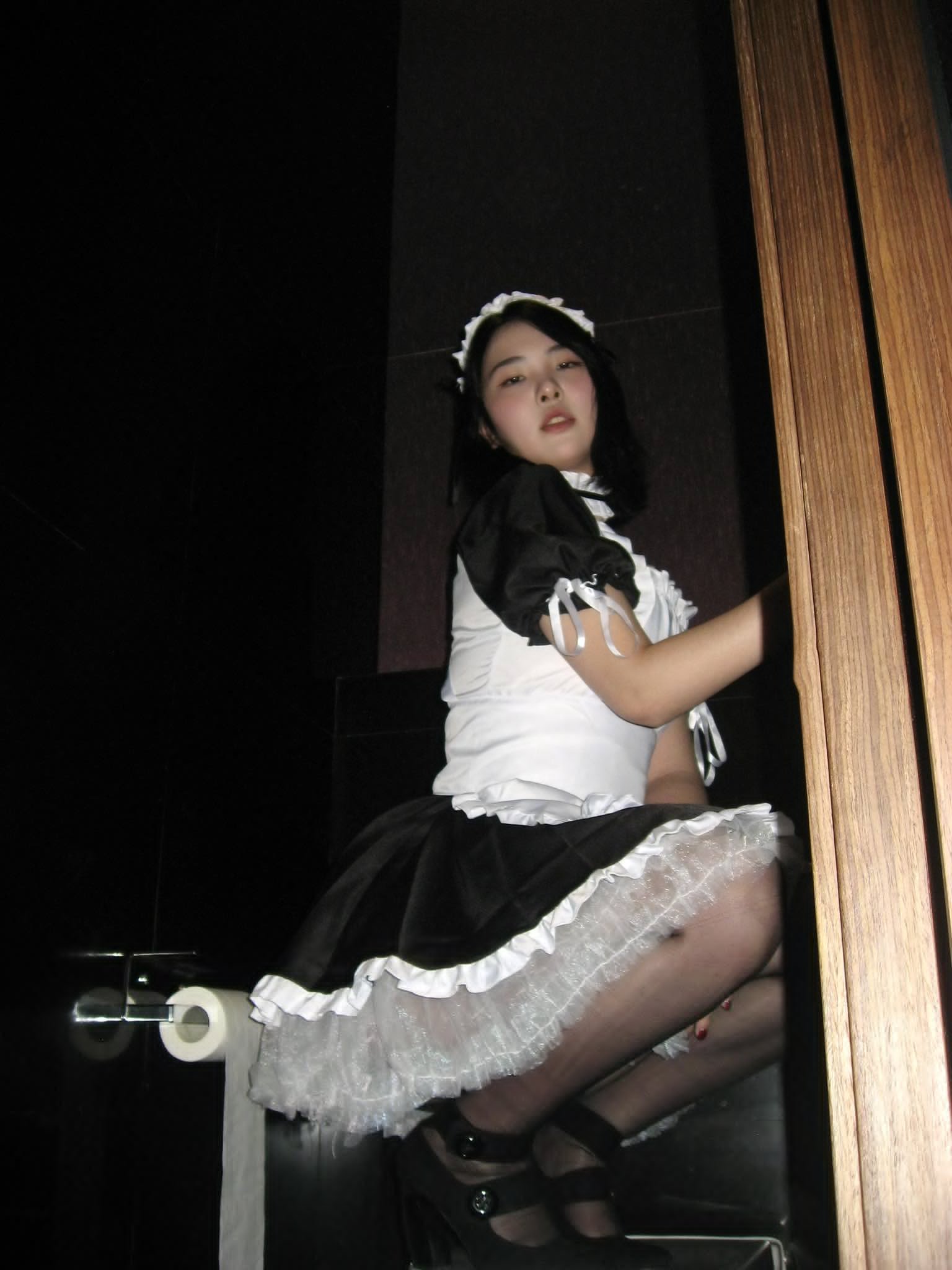 穿着女仆的服装的女人为一张照片。